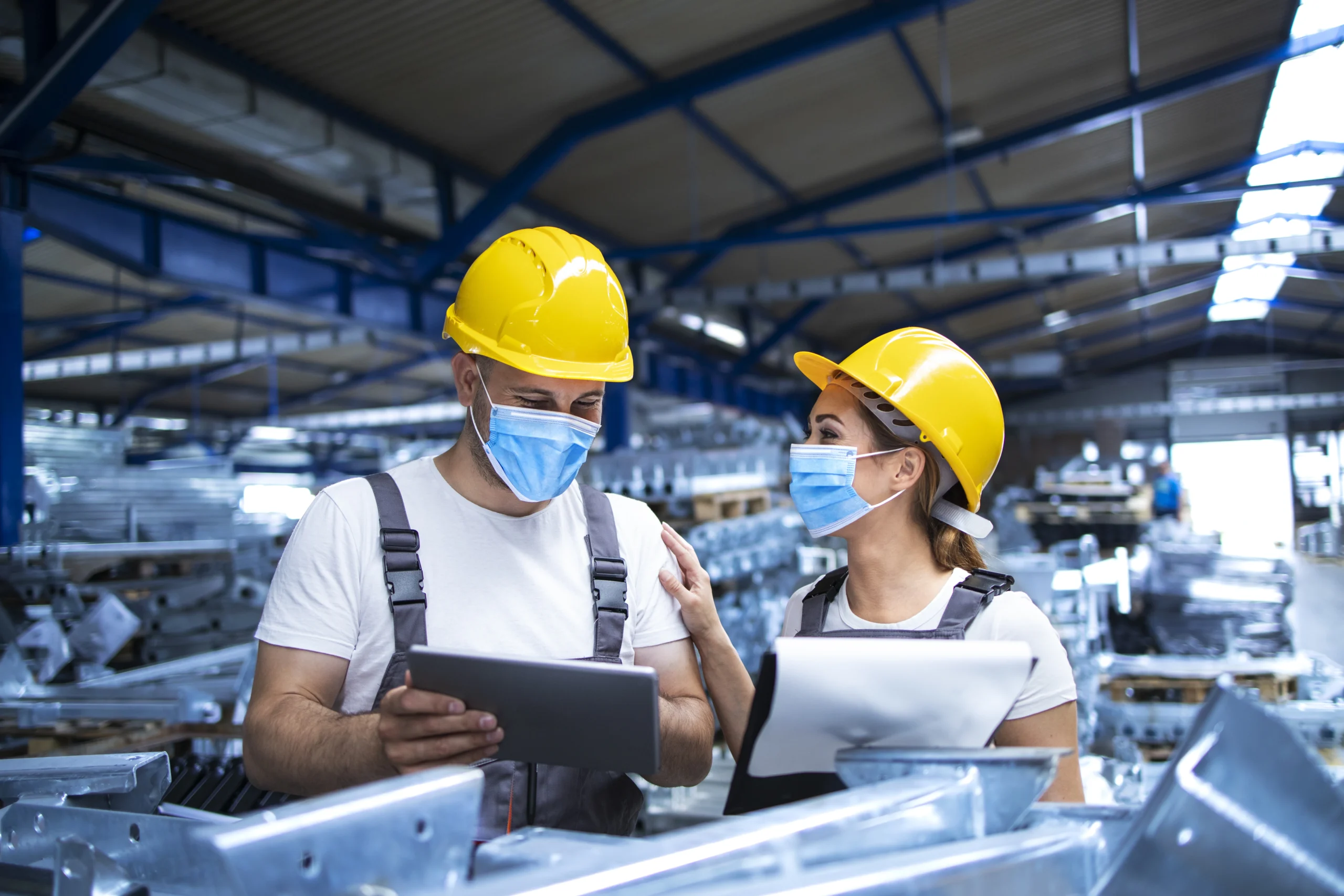 industrial workers with face masks protected against corona virus analyzing results production factory scaled